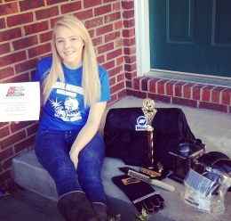 Chrissy posing with her gear and awards